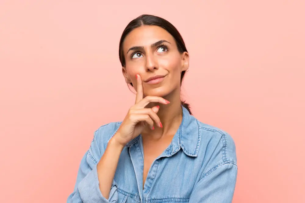 Young woman over isolated pink background thinking an idea